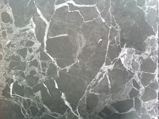 Dark marble texture. Polished natural stone with white veins, lines.