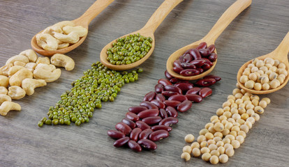 Variety of beans included cashews,green beans,red beans and soy beans  close up on wooden table  Food,ingredients,nature concept