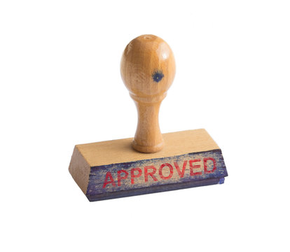 Used, ink stained stamp on a white background with the word Approved