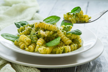 delicious pasta dish with creamy spinach sauce decorated with spinach leaves on grey wooden background - Powered by Adobe