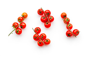 Fresh red cherry tomatoes scattered on white background top view