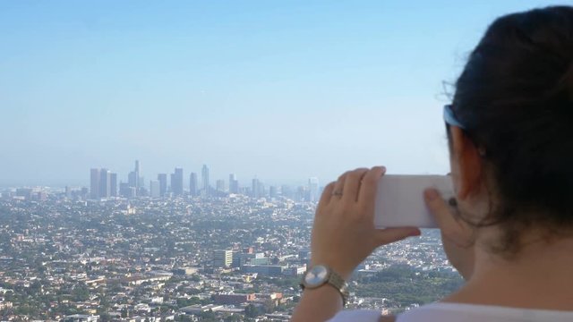  Professional video of woman taking picture of downtown in Los Angeles in 4k slow motion 60fps  