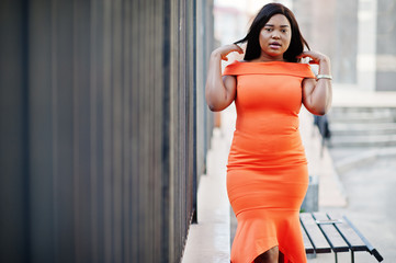African american woman model xxl in orange dress.
