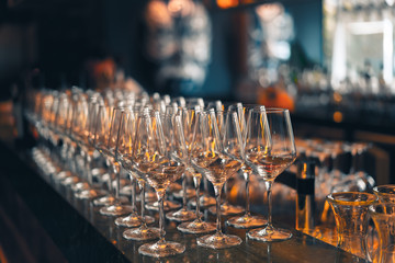 Wine glasses lined up on bar