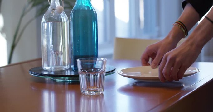 Teenager setting dinner table after school