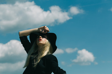 Retro girl in black elegant retro hat and red lips. Retro fashion woman model pose outdoor, copy space.