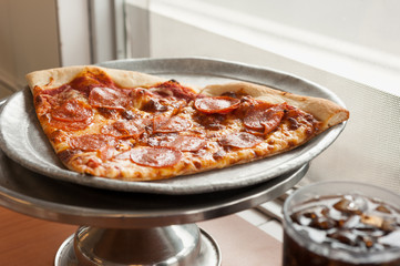 Tow Pepperoni Pizza Slices Served with Soda by the Window