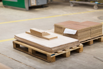 production, manufacture and woodworking industry concept - wooden boards and chipboards storing at furniture factory