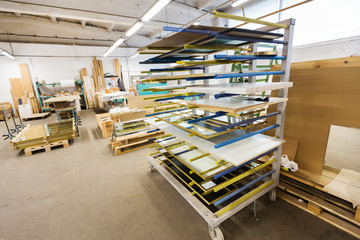 production, manufacture and woodworking industry concept - boards storing at furniture factory workshop