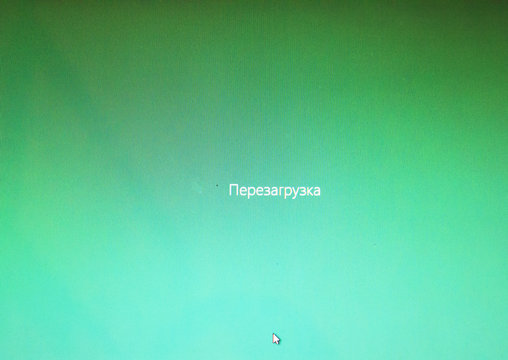 Pale green background. The cursor is on the screen. The inscription reboots both in Russian and English
