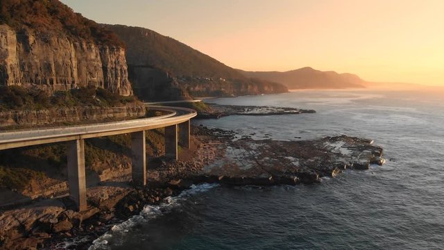 Aerial footage Australia sea cliff bridge coastal drive sunrise coastal seascape
