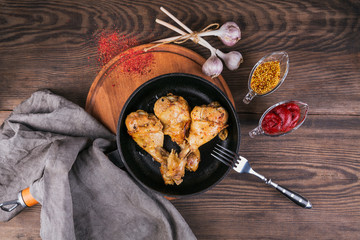 Fried chicken legs with sauces in pan