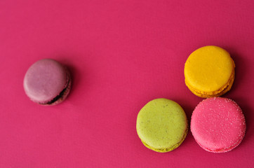 four macaroons on a pink background with a place under the text