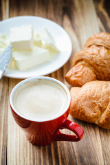 cup of coffee and croissants with butter