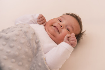 Happy baby on a bed in sleeping support pillow 