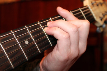 playing guitar,  hand on fretboard guitar on wooden background