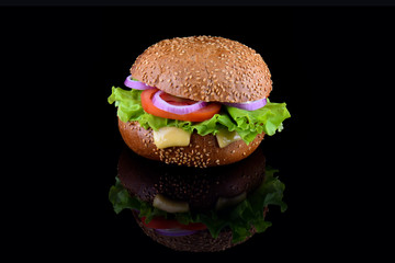 Fresh tasty burger isolated on black background. Tasty and appetizing cheeseburger. Vegetarian burger