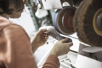 Woman designer making handmade shoes in her workshop