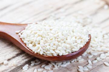 Sesame seeds in a wooden spoon closeup