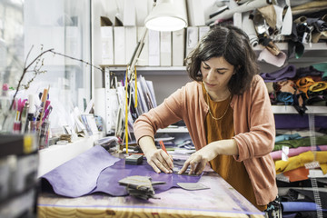 Woman designer making handmade shoes in her workshop
