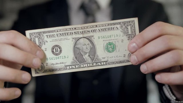 Successful man in a classic suit shows a banknote
