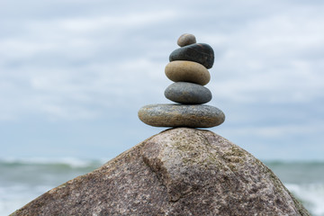 Stacked Stones on top of a huge stone in the ocean