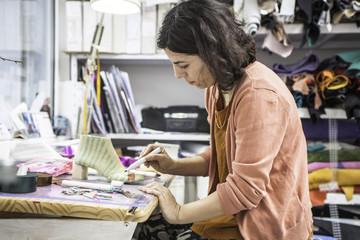 Woman designer making handmade shoes in her workshop