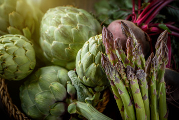 Obraz premium A still life of artichokes and asparagus on the rustic textured background Morning light 2