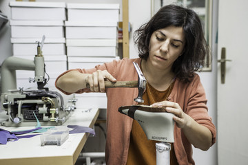 Woman designer making handmade shoes in her workshop