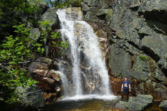 A man standing near waterfall.