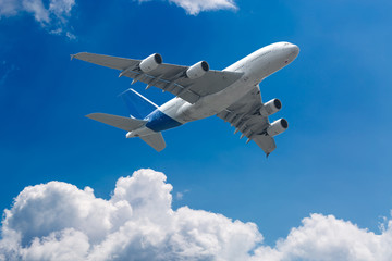 Naklejka na ściany i meble Big four engine plane on the sky with clouds. Aircraft on long intercontinental flights.