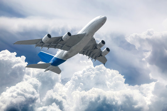  Big four engine plane on the sky with clouds. Aircraft on long intercontinental flights.