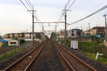 Fototapeta na wymiar Train tracks run through a small neighborhood