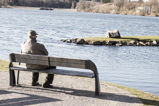 Single old man on sits on a bench