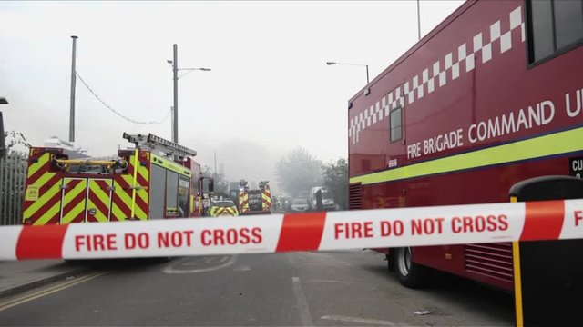 UK April 2018 - Tape that says “Fire, Do Not Cross” cordons off the scene of a fire while London Fire Brigade are at work.