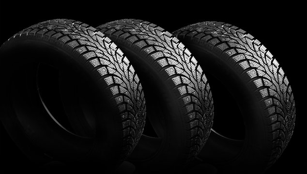  Winter rubber with spikes on a black background close-up.