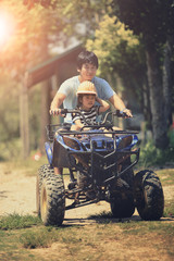 father and daughter riding on quad atv on dirt field © stockphoto mania