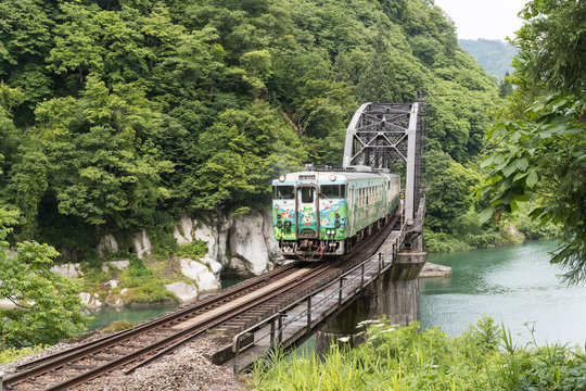 FUKUSHIMA, JAPAN - June 18 : The local train Tadami line and Tadami river on June 18 , 2017 in Fukushima , Japan. This train services in East Japan railway company's Tadami line.