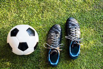 Closeup of soccer ball and football shoes on grass