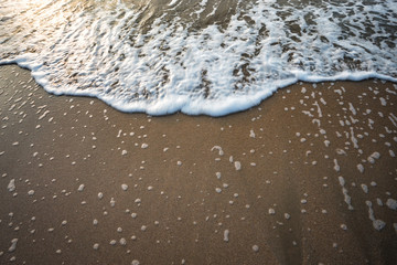 Wave on the sand when Sunset background.
