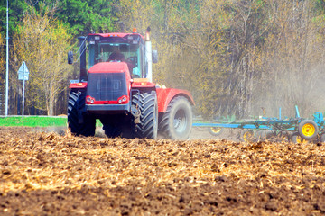 Fototapeta na wymiar Farmer in tractor preparing land with seedbed cultivator