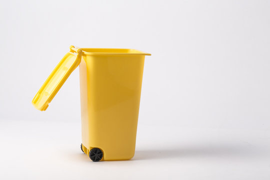 yellow plastic trash bin from paper isolated on white