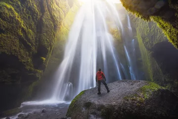 Fototapeten Mann, der den Gljufrabui-Wasserfall in einer Höhle in Island betrachtet © Beboy