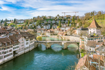 Fototapeta na wymiar Bern, Switzerland. View of the old city center and Nydeggbrucke bridge over river Aare.