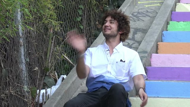 Handsome young man laughing on an outdoor stairway
