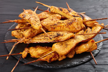 Chicken satay on a black slate tray