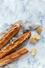 Artisanal freshly baked baguettes and sliced sliced baguette.