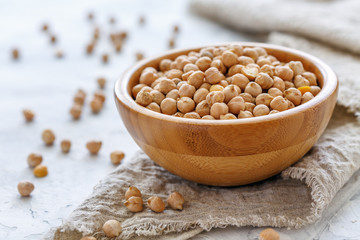 Chickpeas in wooden bowl on a linen cloth.