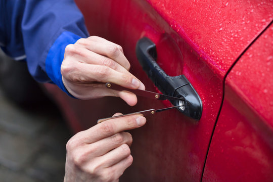 Person Opening Car Door With Lockpicker