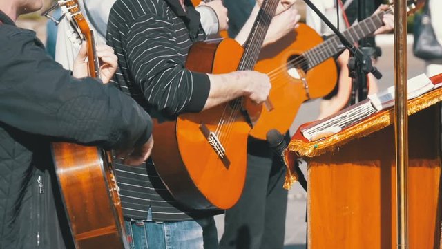 Street musician band playing on the acoustic guitars. Slow Motion in 96 fps. Street Guitarists Playing on Sunny day.